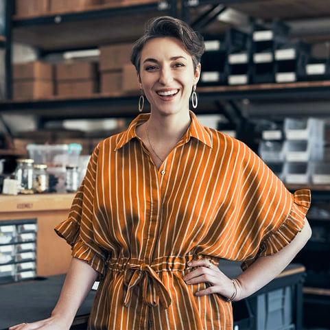 A happy woman inside her business warehouse