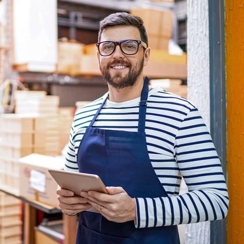 man-inside-warehouse-full-of-parcels-smiling-1080x1080