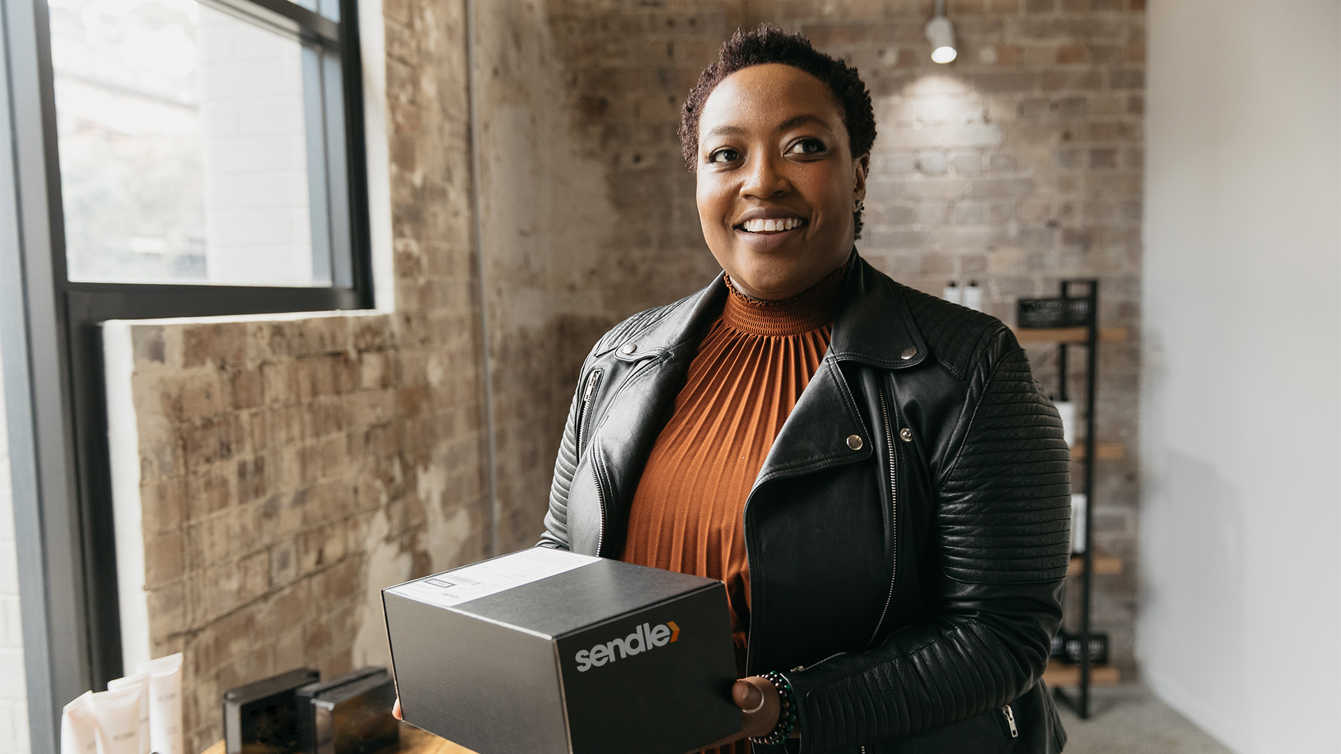 Black woman small business owner holding an eco-friendly box parcel package