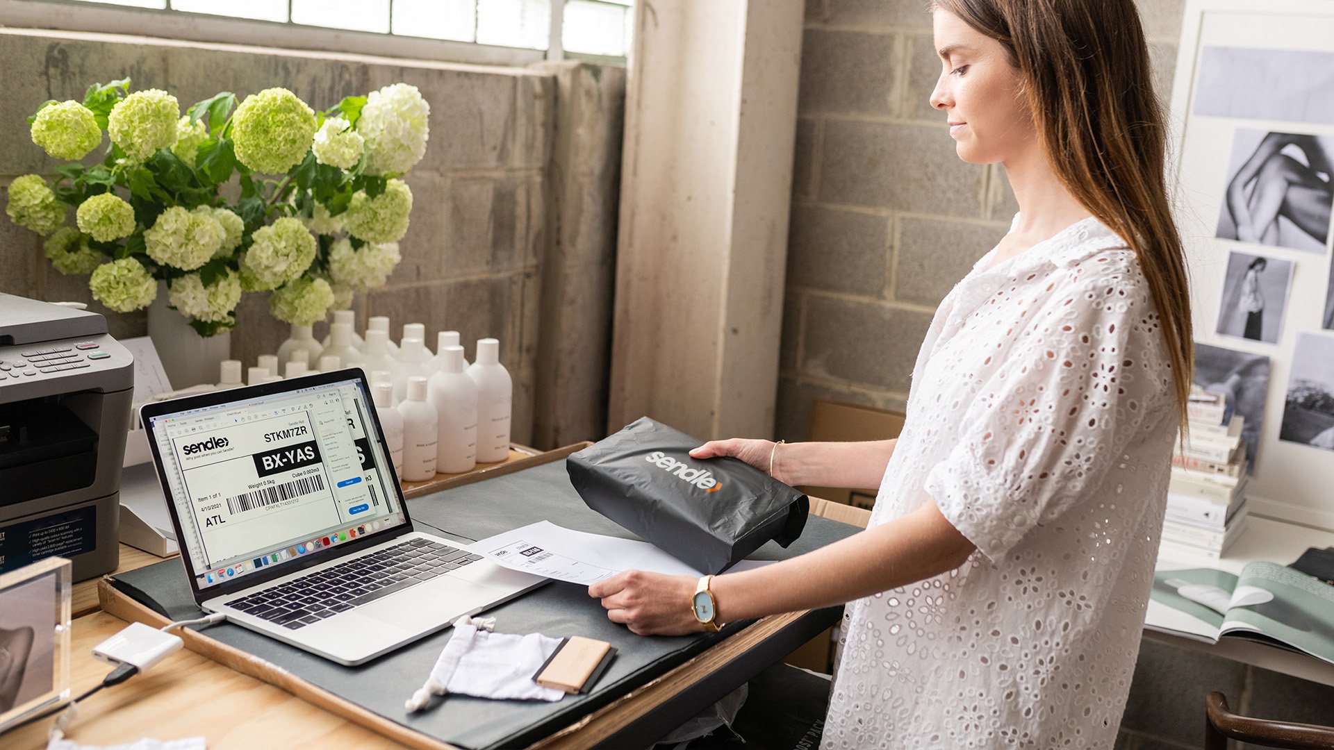 Small business woman standing while printing a shipping label for Sendle deliveries