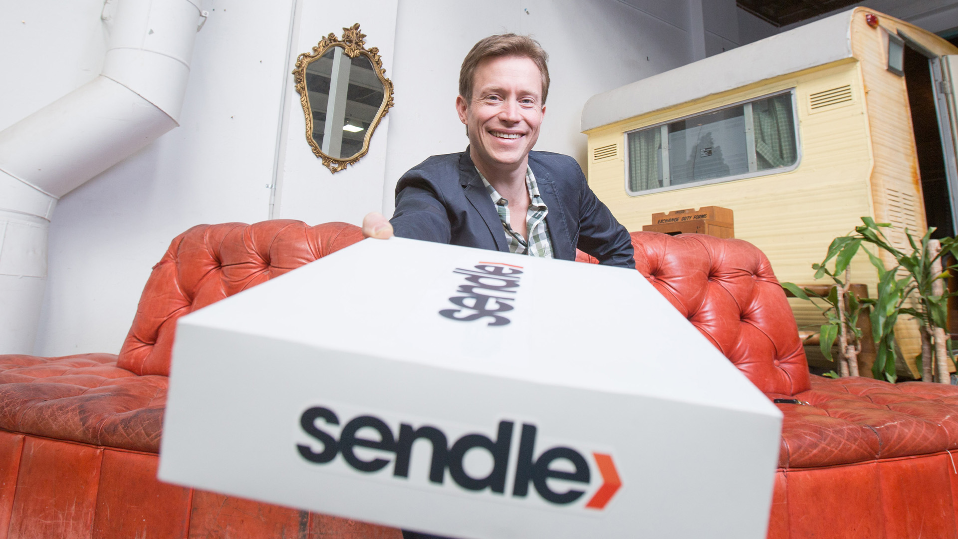Sendle CEO Founder, James Chin Moody holding a white package parcel box