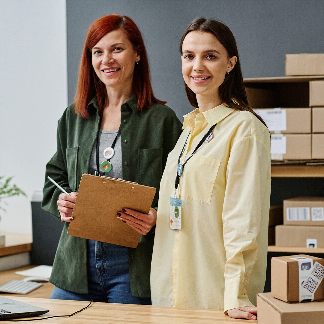 two-women-inside-logistic-office-smiling-1080x1080