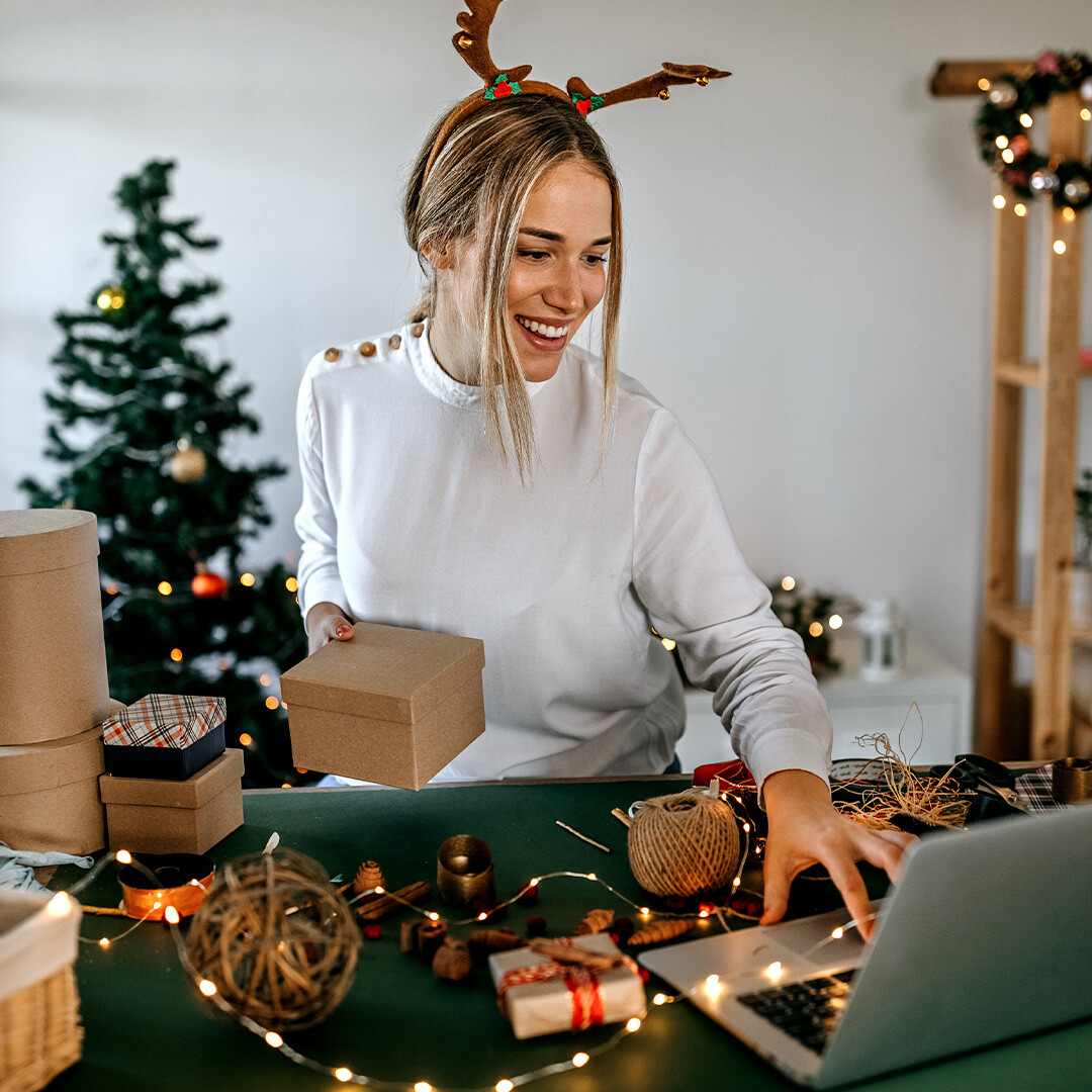 happy-woman-checking-on-laptop-for-holiday-shipping-guide