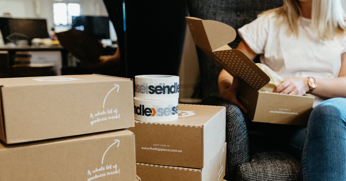 woman preparing to ship with boxes with sendle tape